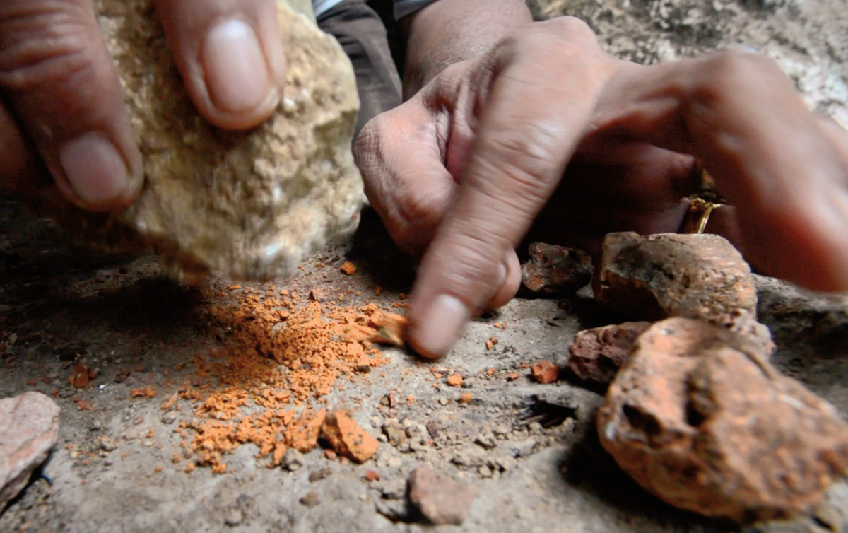 <p>Pulverizing ochre that remains common in the area, Ramli demonstrates the first step in making the pigment used for many of the drawings.</p>

