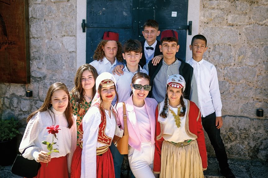A tourist in Mostar poses with local children in traditional Bosnian dress near the Old Bridge ahead of this summer’s celebration marking 20 years since its reopening.