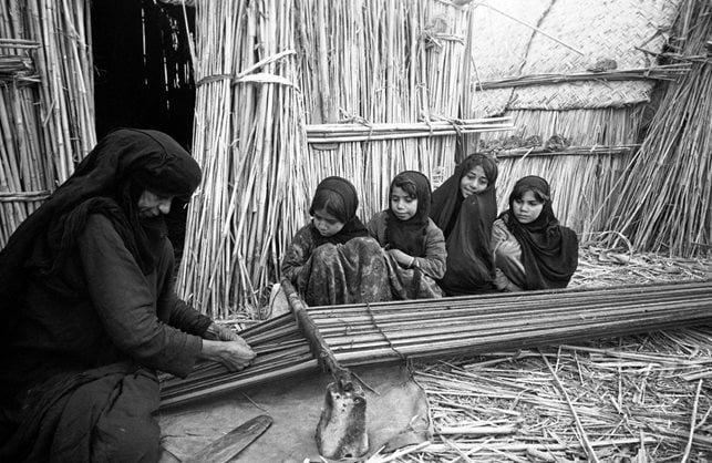 Lesson time for these girls meant watching their grandmother weave on a ground loom with a reed heddle, supported on stones. The girls would soon make their own attempts at weaving.