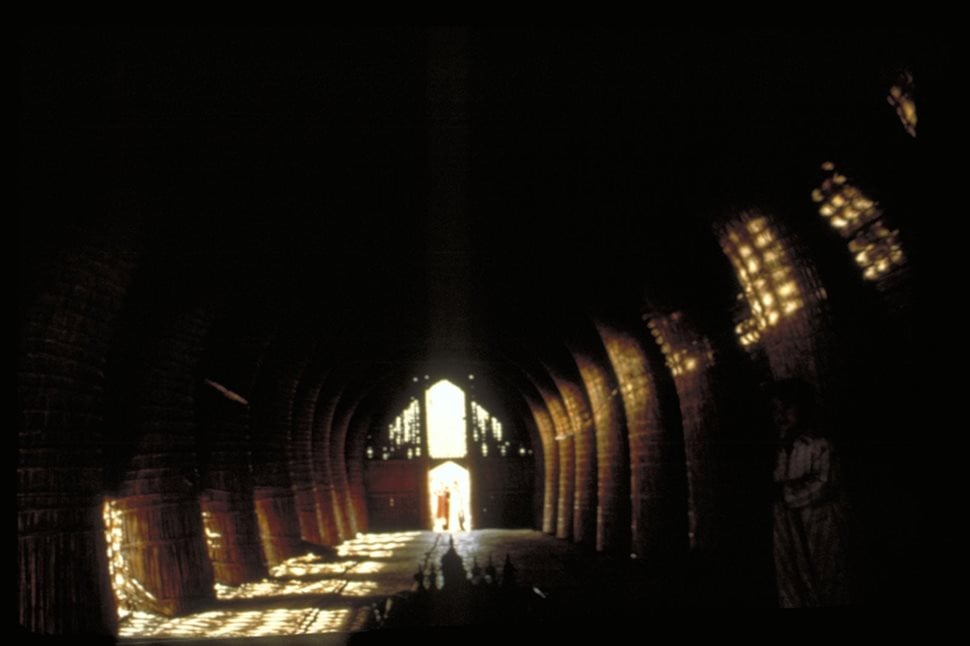 Shafts of light penetrate the dark interior of a reed house.