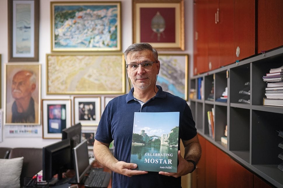 Slađan Jakirović, one of the key members of the team tasked with rebuilding the Old Bridge, poses with a copy of Amir Pašić’s book Celebrating Mostar, about the reconstruction of the old town.