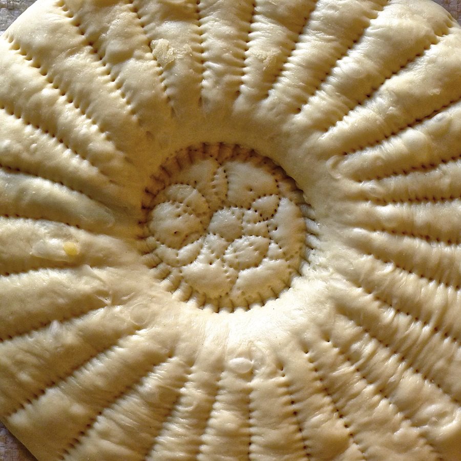 <p>Tashkent-style non dough is stamped with chekich and bosma patterns, and it is ready for the oven.</p>
