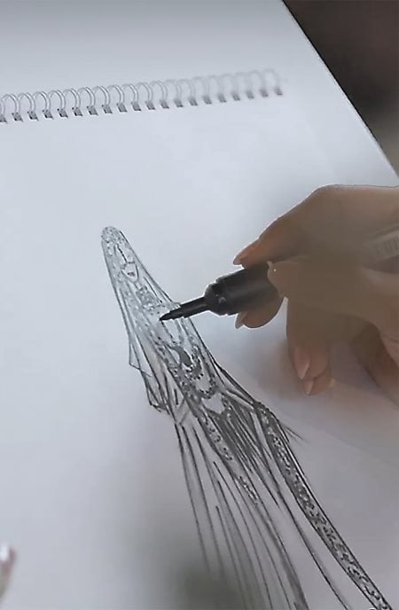 Abid sketches a dress that would be worn by Saudi television presenter Lojain Omran. 