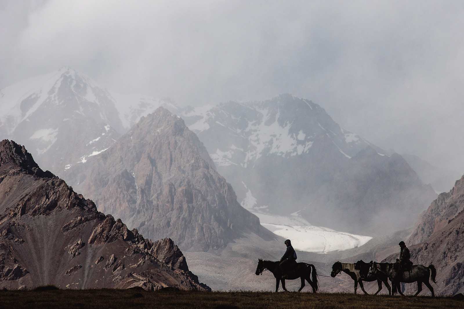 Little explored for tourism and not a popular destination even among locals, this section of the Tien Shan mountains, some 360 kilometers east of Bishkek, Kyrgystan’s capital, lies near the border with China. We trekked down a rough pasture road off the highway that winds towards the village of Enilchek. With Kyrgyzstan’s borders effectively closed to tourists in summer 2020 because of the pandemic, many in the domestic tourism sector took to the mountains to find trekking routes and local travel destinations. Spurred by a pretty view from the bottom of the valley and tempting topography on the map, along with friends from Kyrgyzstan Tourism, we headed up the Kuylu Valley. On our final evening, while laying out our sleeping bags in a vacant hut, local shepherd Altyn (pictured here on the last horse) rode across the river and invited us to join him for a trip to his pastures the next morning.