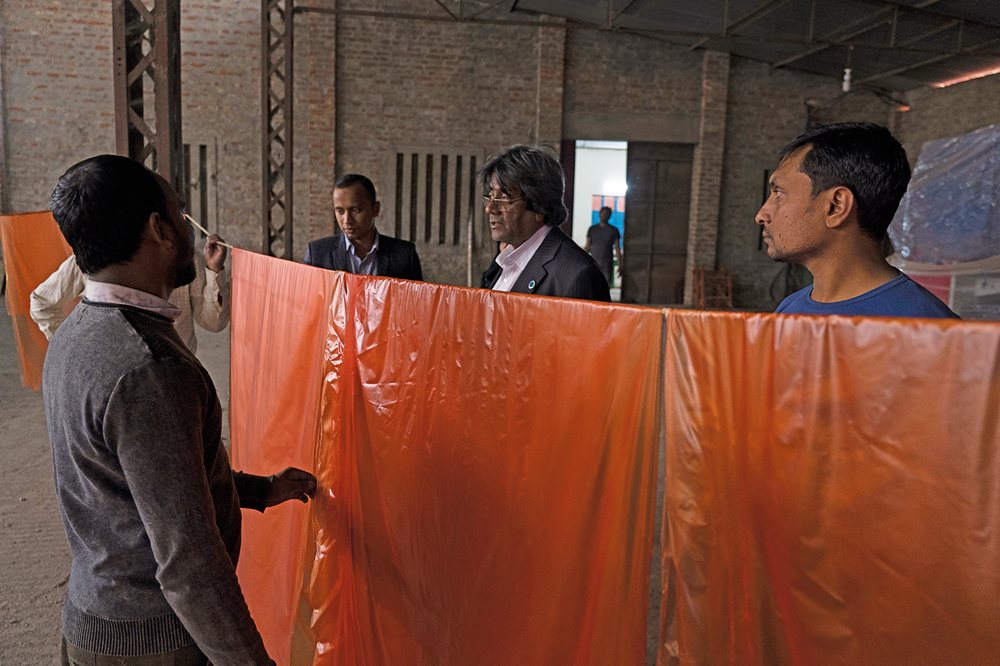 Mubarak Ahmed Khan discusses progress of mass production for jute polymer sheeting&nbsp;at the Latif Bawany Jute Mill, which is daily turning out 100,000 &ldquo;Sonali Bags,&rdquo; <b>below, right</b>, each one a reusable, biodegradable replacement for a polythene grocery bag.