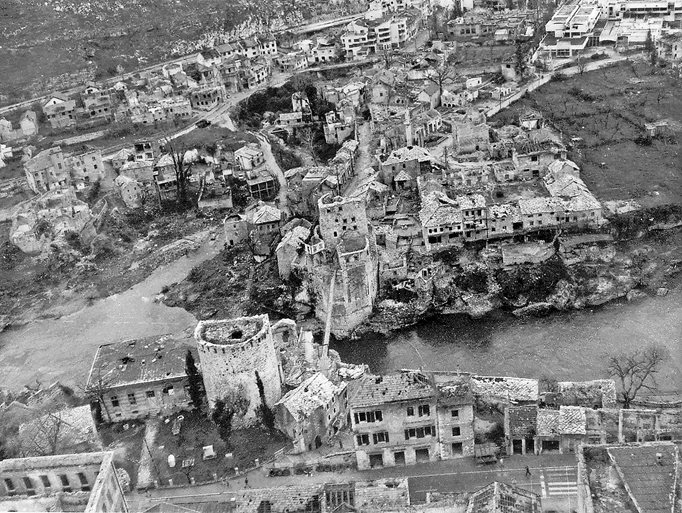 A historical photo shows the wartime destruction of the Old Bridge and its surroundings. 