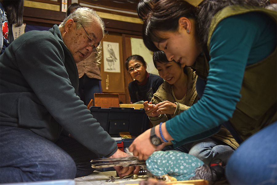 <p>During a weekend workshop for young falconers, Otsuka and Tagomori train students how to care for raptors&mdash;prune feathers, clip and sharpen talons, feed with pigeons and recognize when a bird is stressed or sick. <em>Lower: </em>A student holds a pigeon that will be used in the demonstration.</p>
