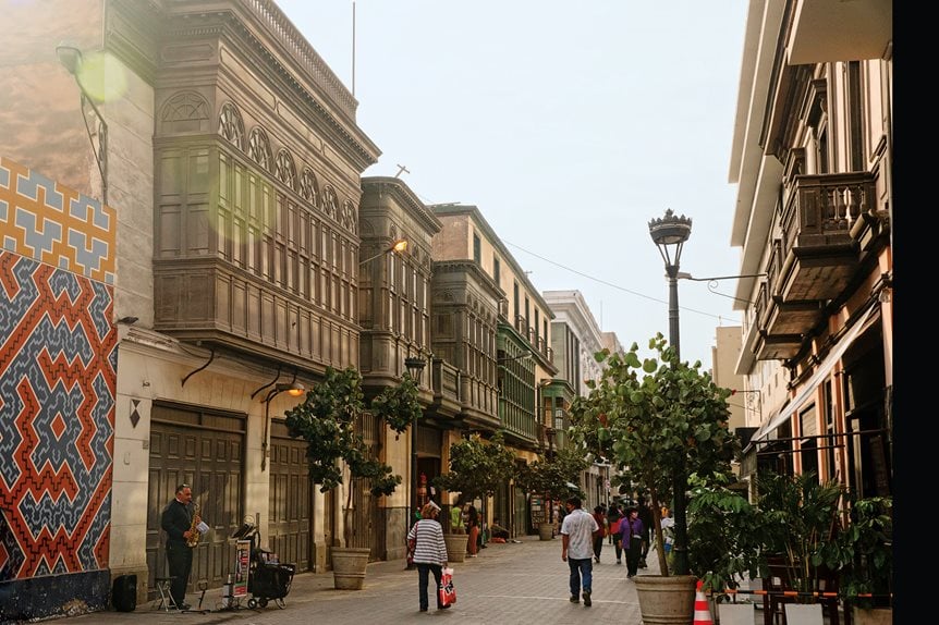 A saxophone player adds his sounds to a late afternoon along Jirón Huallaga near the historic center of Lima. On the left side of the street in this photo, balcones de cajón, or box balconies, reflect the stylistic trend of the 19th century, which covered the windows in glass instead of the turned-wood mashrabiya lattices of Andalusi Arab origin that had been popular since at least the late 16th century.