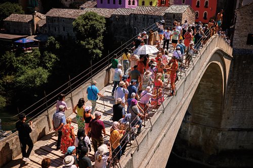 Tourists watch a diver leap into the river Neretva from the bridge, which draws large crowds year-round.