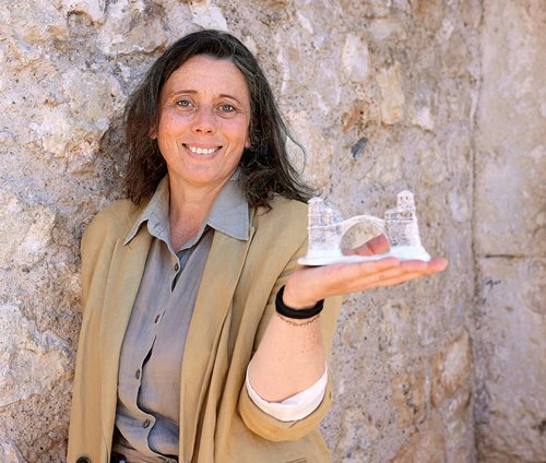 Architect Senada Demirović holds a souvenir replica of the bridge, which she helped rebuild.